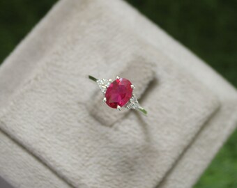 Anel de noivado/casamento em prata de lei com rubi oval de laboratório.