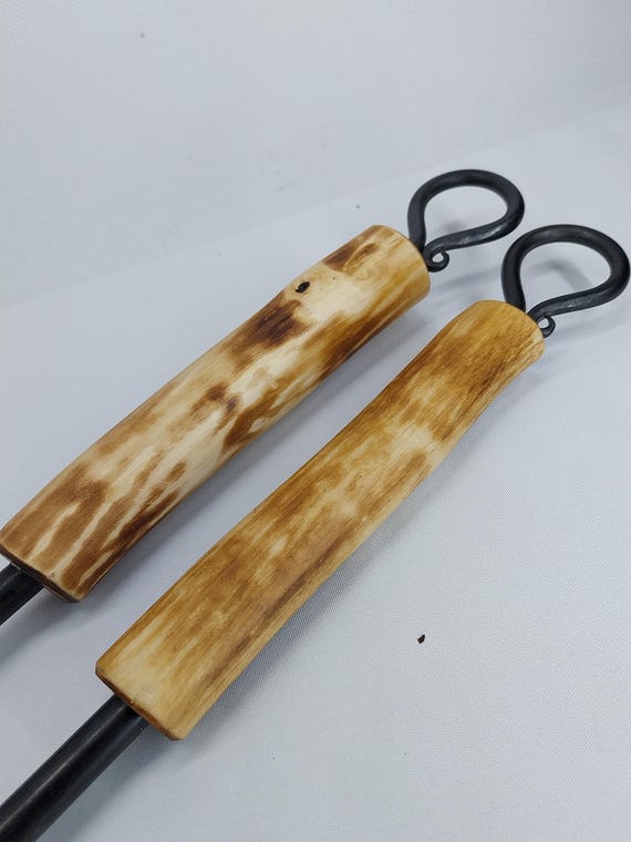 木製ハンドル付き手鍛造鉄製火かき棒。鍛造暖炉用火かき棒。素朴な錬
