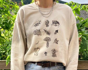 Suéter com estampa de cogumelos e sapos feita à mão em linóleo, blusa de moletom com estampa em bloco.