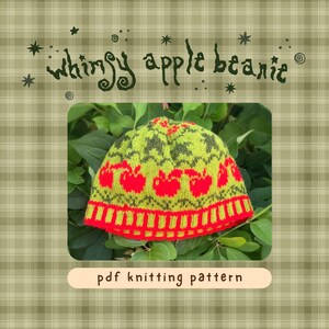 May include: A lime green knitted beanie featuring a repeating pattern of bright red apples and dark green foliage motifs. The hat has a ribbed red and green brim. The text "whimsy apple beanie" and "pdf knitting pattern" are visible.