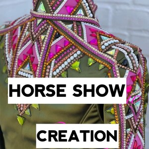 May include: Olive green equestrian show jacket with intricate embellishments. The jacket features pink, white, and iridescent crystal accents, with the text "HORSE SHOW CREATION" in white block letters.