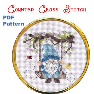 May include: A counted cross stitch PDF pattern featuring a gnome on a swing. The gnome wears a blue hat and beard, swinging under a floral arch. The text "Counted Cross Stitch" and "PDF Pattern" are visible.