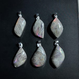 Pu&ograve; includere: Sei ciondoli con pietre preziose con bails color argento. I ciondoli hanno un colore di base grigio con lampi iridescenti di rosa, viola e verde. Le pietre sono lucide e hanno una superficie liscia. I ciondoli hanno forme a goccia e irregolari.