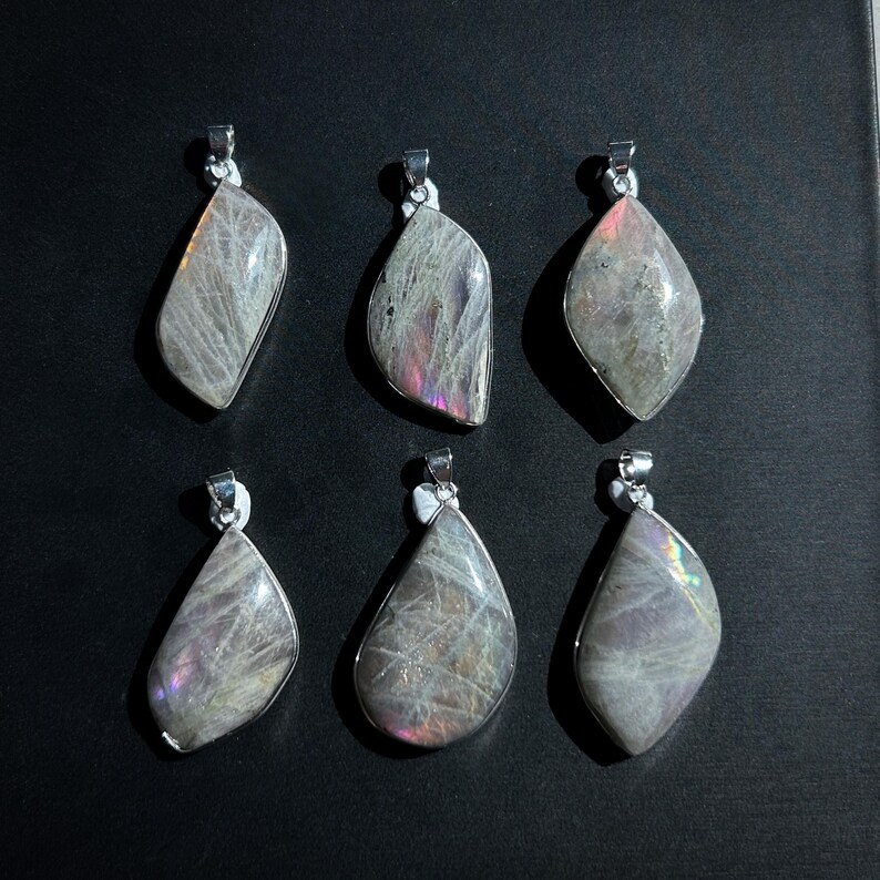 Pu&ograve; includere: Sei ciondoli con pietre preziose con bails color argento. I ciondoli hanno un colore di base grigio con lampi iridescenti di rosa, viola e verde. Le pietre sono lucide e hanno una superficie liscia. I ciondoli hanno forme a goccia e irregolari.