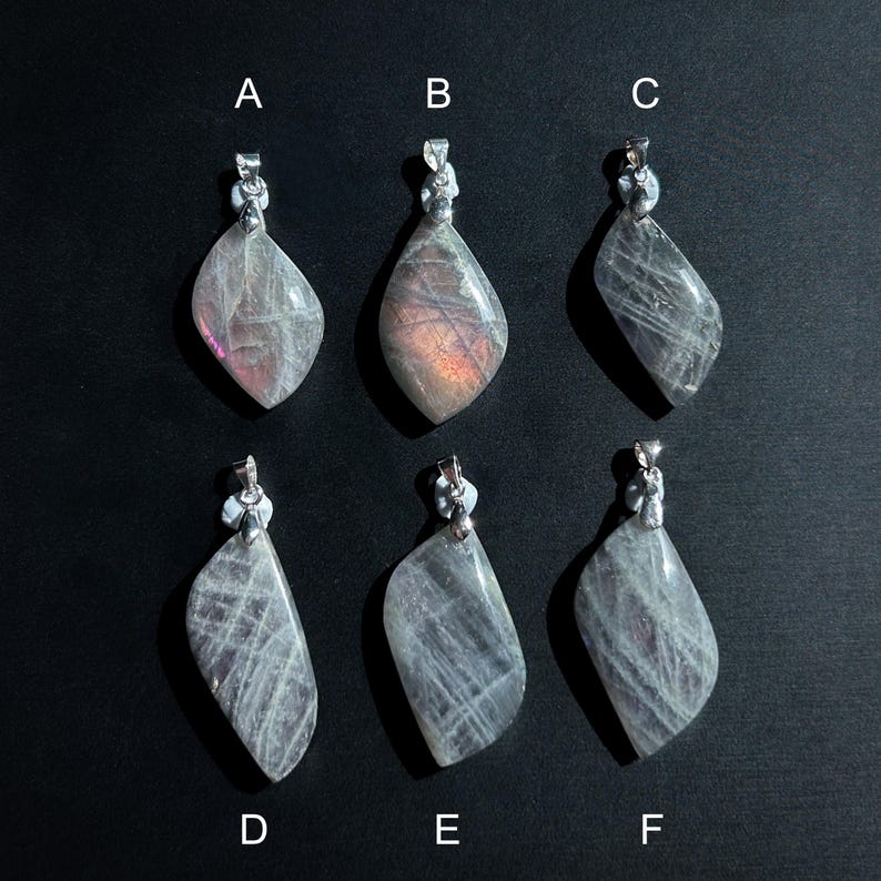 Pu&ograve; includere: Sei ciondoli con pietre preziose con bails color argento sono esposti su sfondo nero. I ciondoli sono a forma di goccia, con un mix di grigio traslucido e tonalit&agrave; iridescenti rosa e viola. Ogni ciondolo ha un motivo unico.