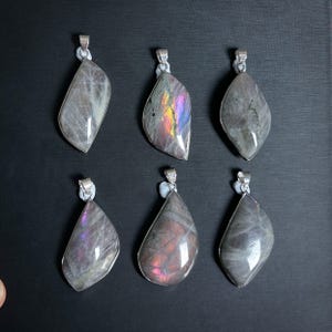 Pu&ograve; includere: Sei ciondoli con pietre preziose con bails color argento. I ciondoli hanno varie forme, tra cui a goccia e irregolari. Le pietre mostrano una gamma di colori, tra cui grigio, viola e lampi iridescenti.