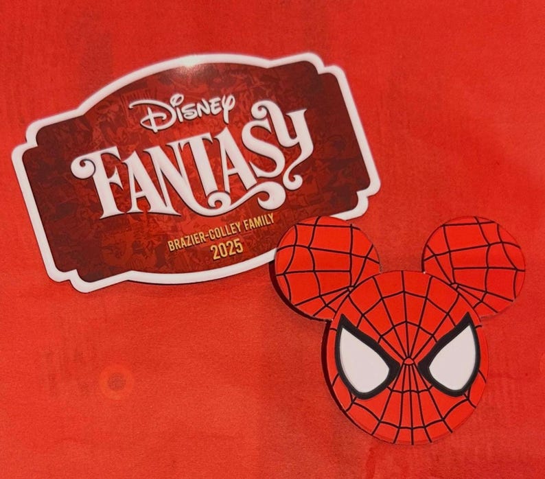 May include: A red Spider-Man-themed Mickey Mouse head-shaped design with a web pattern and white eye details. Next to it is a maroon and white Disney Fantasy sticker with the text "BRAZIER-COLLEY FAMILY 2025" on a red background.