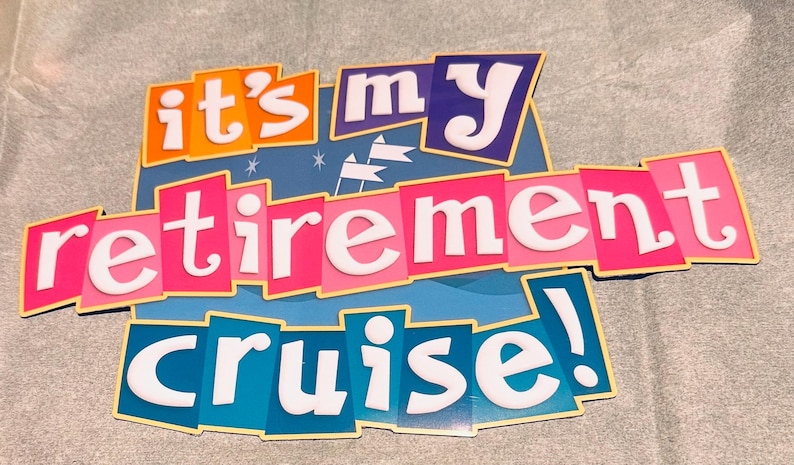 May include: A decorative sign featuring the text "it's my retirement cruise!" in white letters. The words are arranged on colorful, overlapping rectangular panels in shades of orange, purple, pink, and blue, with small white flag icons.