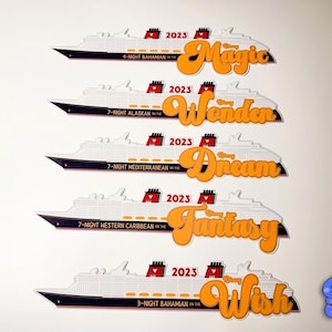 May include: White cruise ship cutouts with black and red accents, featuring orange text with the names "Magic", "Wonder", "Dream", "Fantasy", and "Wish". Each ship has the year "2023" and a cruise destination.