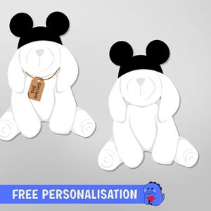 May include: Two white cartoon bunnies wearing black hats with Mickey Mouse ears. One bunny has a tag that says "The Smiths". The image has a blue banner at the bottom that says "FREE PERSONALISATION".