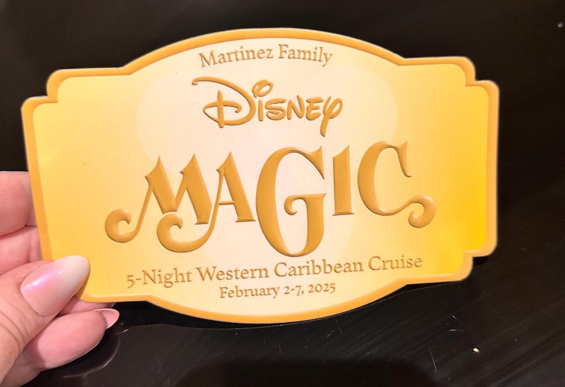 May include: A golden-yellow Disney Magic cruise card with the Martinez Family name. The card features the Disney logo and the word "MAGIC" in large, embossed letters. It also states "5-Night Western Caribbean Cruise, February 2-7, 2025."