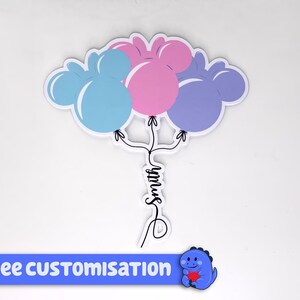 Pode incluir: Um adesivo com tr&ecirc;s bal&otilde;es em forma de Mickey Mouse em azul, rosa e roxo, com o nome "Smith" escrito em it&aacute;lico abaixo. O adesivo tem uma faixa azul na parte inferior que diz "FREE CUSTOMISATION".