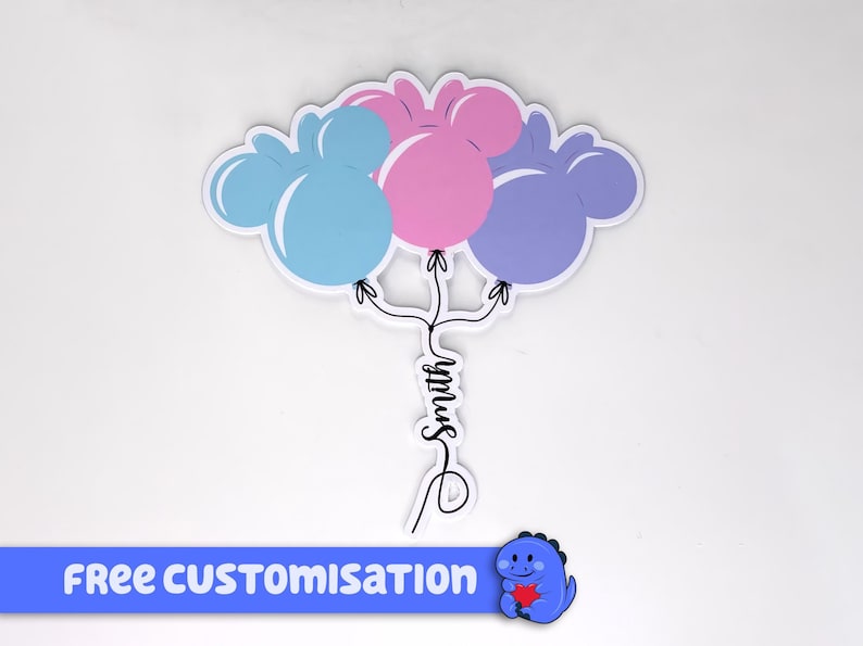 Pode incluir: Um adesivo com tr&ecirc;s bal&otilde;es em forma de Mickey Mouse em azul, rosa e roxo, com o nome "Smith" escrito em it&aacute;lico abaixo. O adesivo tem uma faixa azul na parte inferior que diz "FREE CUSTOMISATION".
