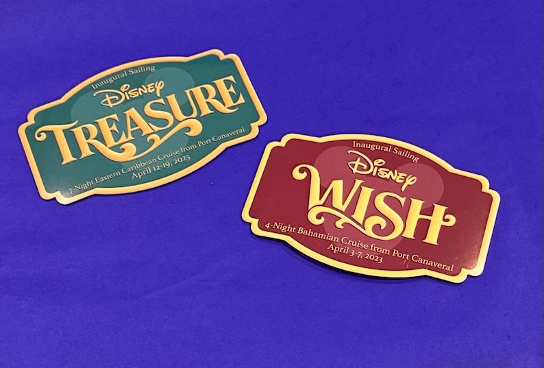 May include: Two rectangular Disney cruise magnets. One is teal with "TREASURE" in gold script. The other is maroon with "WISH" in gold script. Both have cruise details and dates.