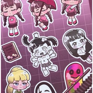 May include: A sheet of stickers featuring various cartoon characters with different expressions and poses. The stickers include a girl with braids, a girl with an umbrella, and a ghost-like figure. The color palette includes pink, black, white, and purple.