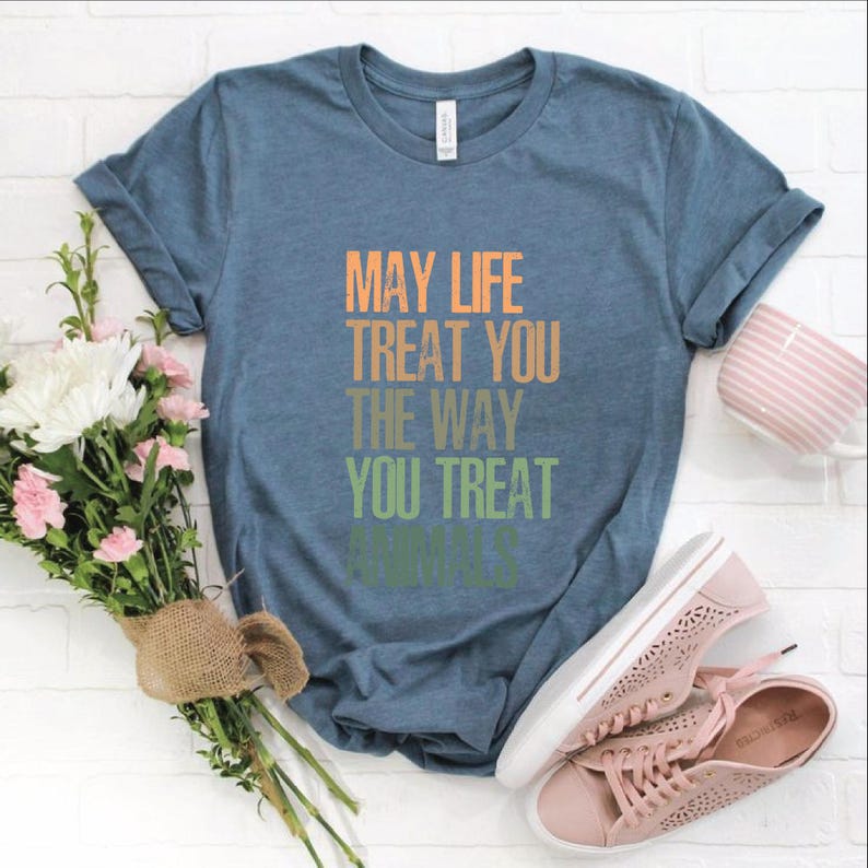 May include: A blue t-shirt with the text "May life treat you the way you treat animals" printed in a rainbow gradient.