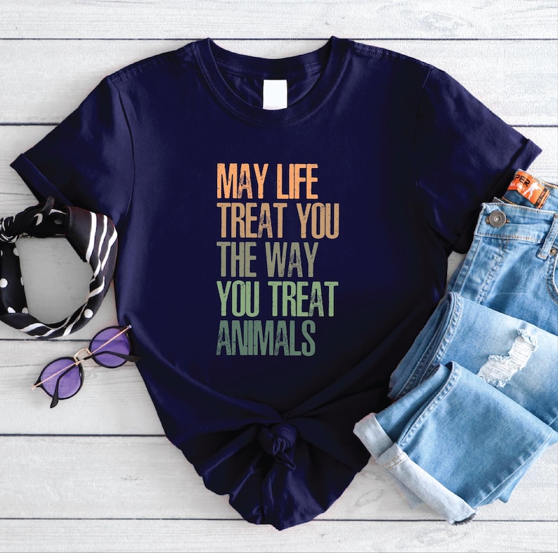 May include: A navy blue t-shirt with a vintage-style graphic that reads "May life treat you the way you treat animals".