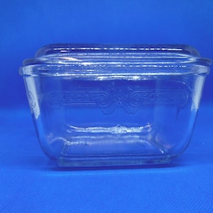 Peut inclure: Un plat à four en verre transparent avec un couvercle. Le plat a un motif décoratif autour du bord.