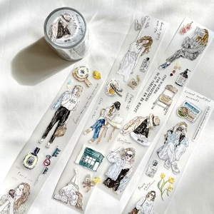 May include: Three rolls of clear washi tape with illustrations of women in various poses. The tape features a variety of designs, including flowers, coffee cups, and buildings. The text on the tape reads "Dance lightly with life", "Stop waiting to be perfect to be happy for everything", and "Life is a collection of moments".