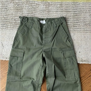 May include: A pair of olive green cargo pants with two large cargo pockets on the front.