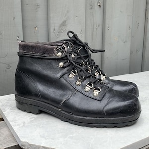 May include: Black leather hiking boots with a lace-up closure and a thick rubber sole.
