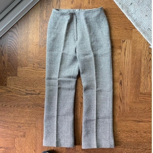 Puede incluir: Pantalones acampanados de tweed gris con cintura alta y cierre de cremallera.