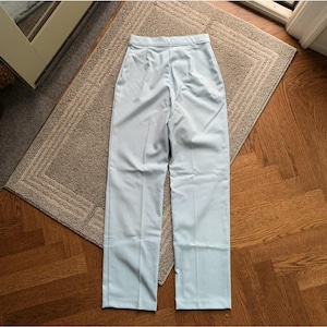 May include: Light blue trousers with a straight leg and a high waist.