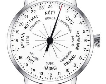May include: A silver wristwatch with a white face and black leather band. The face has a compass-like design with numbers 1 through 24 around the edge. The words "Nótt", "Morgunn", "Ótta", and "Dagmal" are printed on the face, along with the words "Norðr", "Austr", "Suðr", and "Vestr".