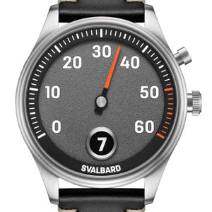 May include: A silver wristwatch with a black leather strap. The grey watch face features white numerals and an orange second hand. The watch is marked with the word "SVALBARD" at the bottom.