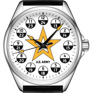May include: A wristwatch with a silver-tone case and a black leather strap. The white dial features a large yellow star in the center, the text U.S. ARMY, and circular markers displaying both 12-hour and 24-hour time formats in black and white.