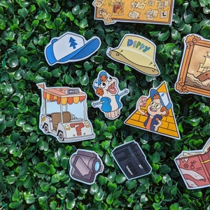 May include: A collection of vinyl stickers featuring Gravity Falls imagery, including a corkboard with the text Who Is The Author, a blue and white cap, a yellow bucket hat labeled Dippy, a golf cart, a puppet, a character on a pyramid, and a tape recorder.