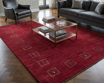 Alfombra Loribaft Gabbeh de lana orgánica tejida a mano, color rojo intenso, estilo persa tradicional, con bordes de pequeños motivos tribales, elaborada artesanalmente con un estilo moderno.
