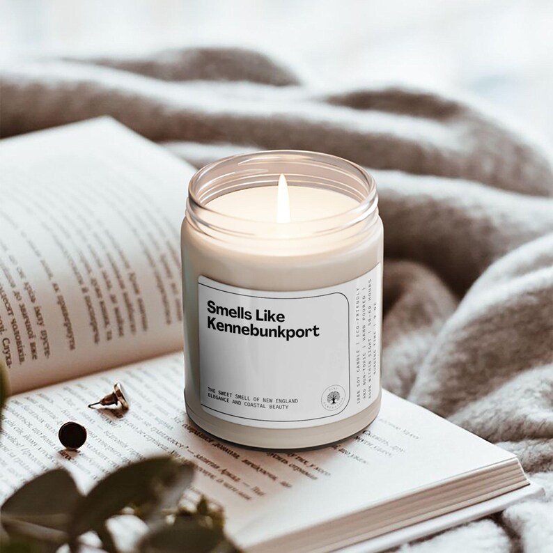 a candle sitting on top of a book next to a plant