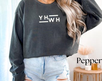 May include: A dark gray cropped sweatshirt with the text "YHW" in white lettering. The sweatshirt is being worn by a person with long blonde hair.