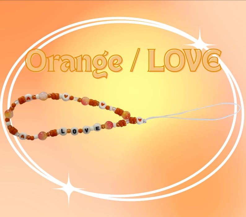 May include: A phone charm featuring orange and white beads, including round beads with the letters L, O, V, E and small heart symbols. The charm includes a white loop attachment and the text Orange / LOVE is displayed above the beaded strand.