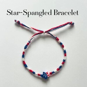 May include: A Star-Spangled Bracelet featuring red, white, and blue braided cord strands. The bracelet includes a central star-shaped charm decorated with a blue field of white stars and red and white stripes, finished with adjustable knotted ends.
