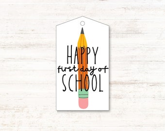 Może przedstawiać: Biała etykieta prezentowa z ilustracją żółtego ołówka i tekstem "HAPPY first day of SCHOOL".