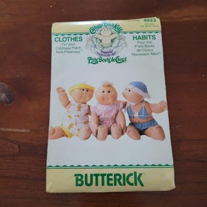 May include: A Butterick 4923 sewing pattern envelope for Cabbage Patch Kids Preemies clothes. The white paper cover features three dolls wearing different outfits, with the text Cabbage Patch Kids, Preemies, and Butterick printed in green.
