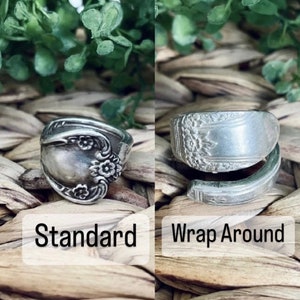 May include: Two silver spoon rings, one in a standard style and the other in a wrap-around style. Both rings feature a floral design.