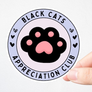 May include: A round sticker with the text "BLACK CATS APPRECIATION CLUB" in a circular design. The sticker features a black cat paw print with pink pads, surrounded by a light purple border and small heart illustrations.