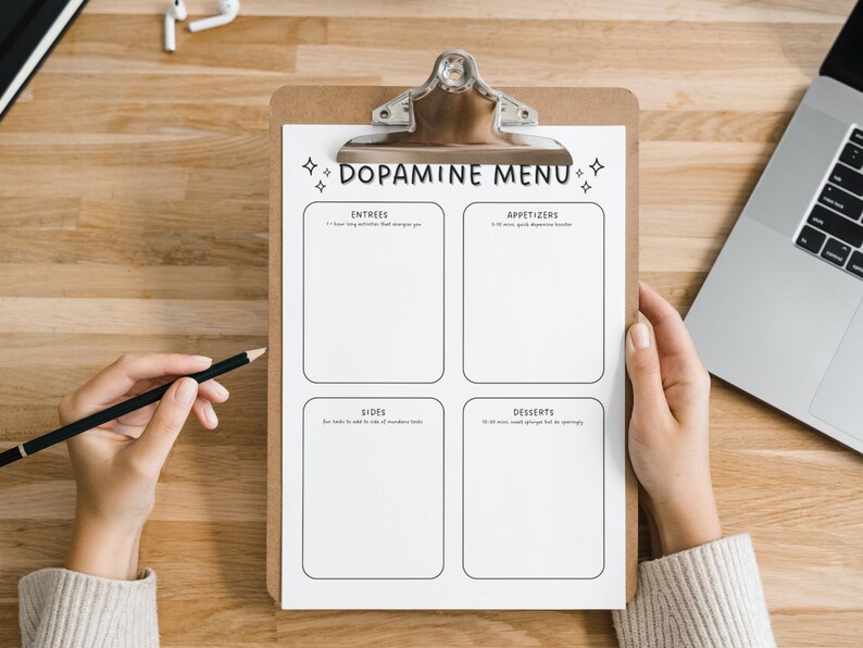 May include: A white clipboard with the text "Dopamine Menu" at the top. The clipboard is divided into four sections labeled "Entrees", "Appetizers", "Sides", and "Desserts".