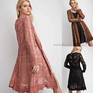 May include: Three long-sleeved lace cardigans in different colors: dusty rose, brown, and black. Each cardigan has a delicate lace pattern and a scalloped hem.