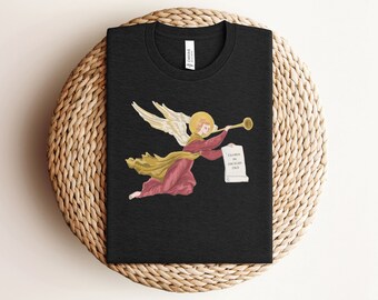 May include: Black t-shirt featuring a graphic of an angel blowing a trumpet and holding a scroll with the text "Gloria in excelsis Deo".