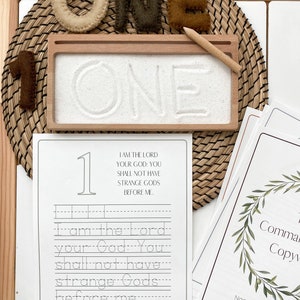 May include: A printable worksheet for learning the first commandment. The worksheet features the text "I am the Lord your God: You shall not have strange Gods before me." and a tracing activity for the number one.