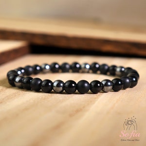 Peut inclure: Un bracelet compos&eacute; de perles noires mates et argent&eacute;es brillantes.