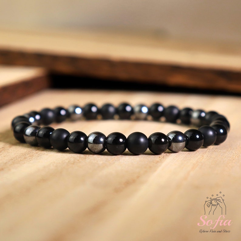 Peut inclure: Un bracelet compos&eacute; de perles noires mates et argent&eacute;es brillantes.