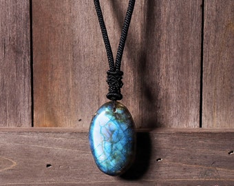 May include: A blue and green labradorite gemstone pendant on a black cord necklace.