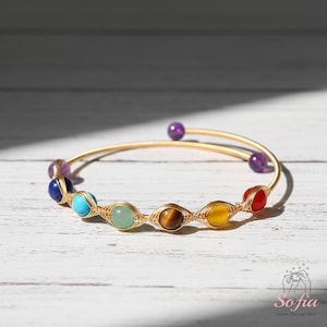 Peut inclure: Ensemble de trois mugs en céramique avec un glaçage moucheté de couleur crème. Chaque mug présente un motif peint à la main différent : une feuille bleue et verte, une fleur jaune et une baie rouge. Les mugs ont une forme simple et arrondie avec une anse confortable.