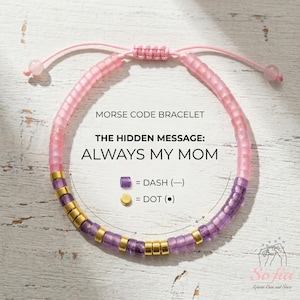 Può includere: Un braccialetto rosa e viola con codice Morse con il messaggio nascosto "ALWAYS MY MOM". Il braccialetto presenta una chiusura a nodo scorrevole ed è realizzato con piccole perline colorate. Il testo sull'immagine spiega i simboli del codice Morse.
