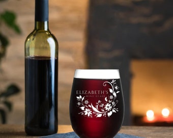 Puede incluir: Una copa de vino de vidrio transparente con un diseño floral y el texto "ELIZABETH'S WINE GLASS" grabado en el lateral. La copa está llena de vino tinto.